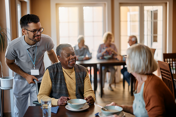 Caregiver assisting residents at mealtime